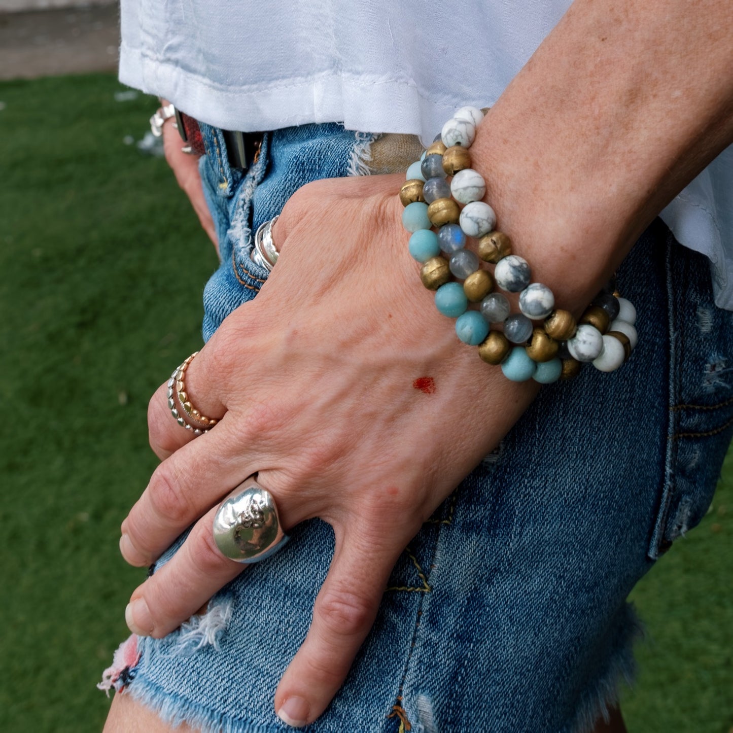 Model stacking the Amazonite Yoga Bracelet with other gemstone bracelets, handmade mindful jewelry from Austin.