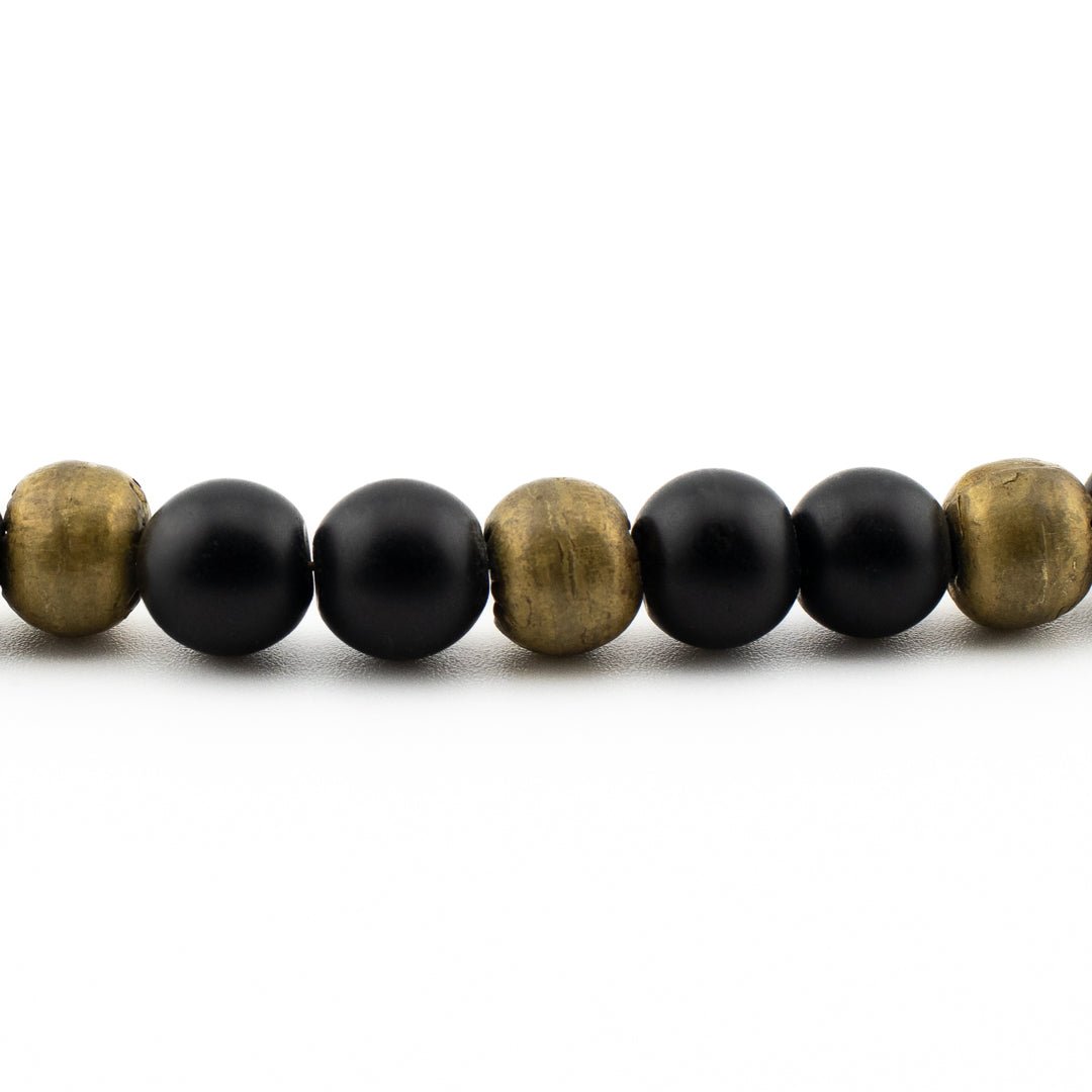 Close-up of polished black onyx beads with glossy finish, handmade yoga bracelet from Texas.