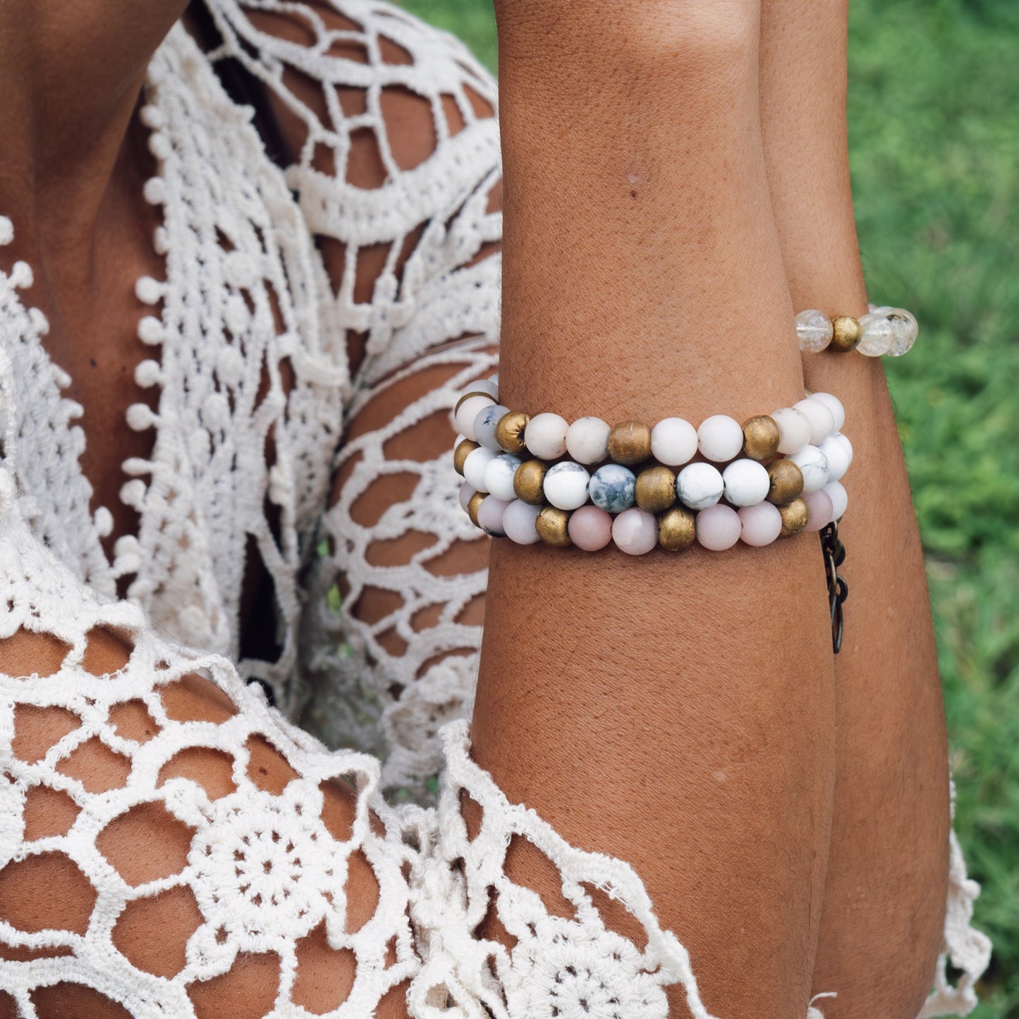 Model stacking the Howlite Yoga Bracelet with other gemstone bracelets, handmade mindful jewelry from Austin.