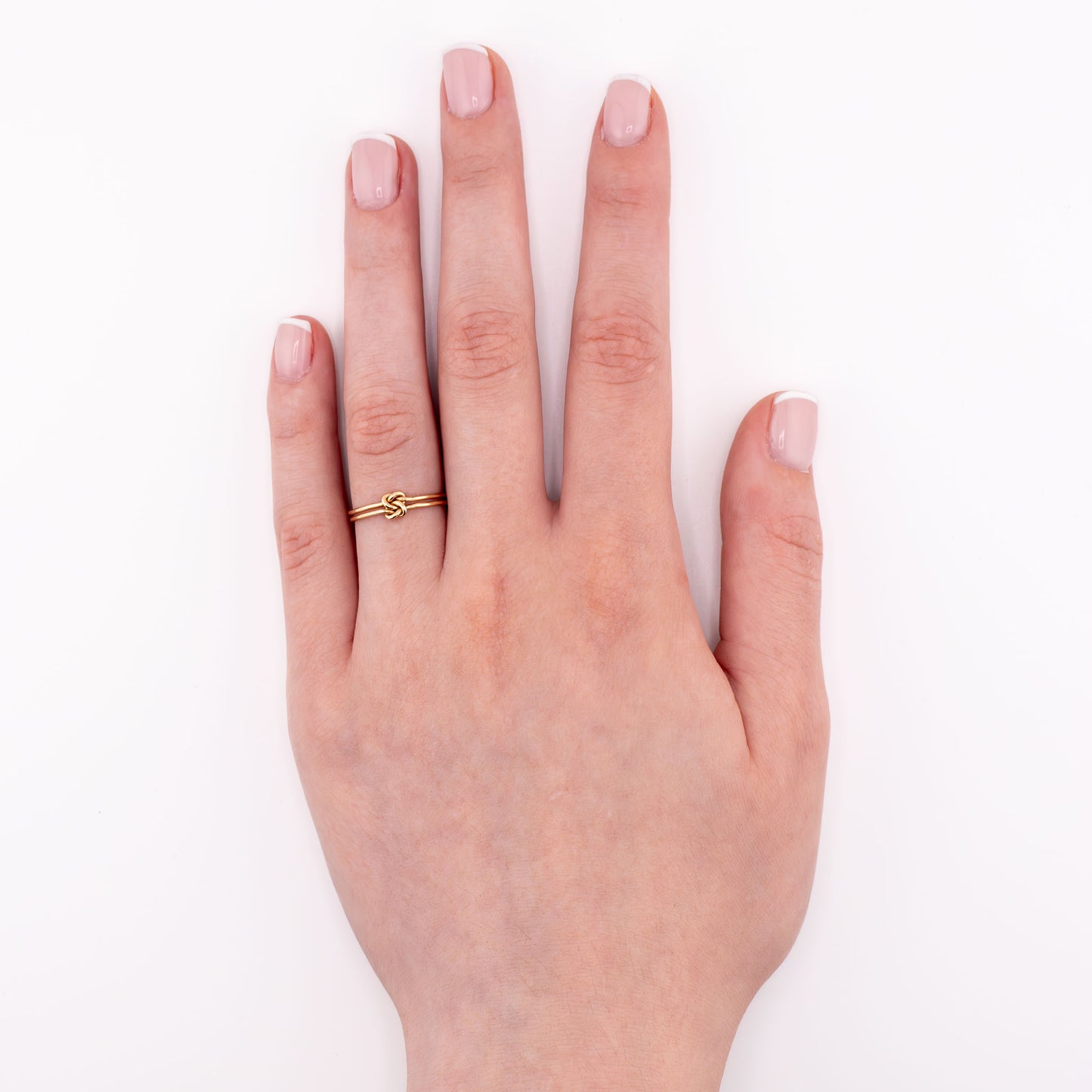 14k gold-filled Love Knot stacking ring on hand model, elegant handmade knot jewelry for stacking or solo wear