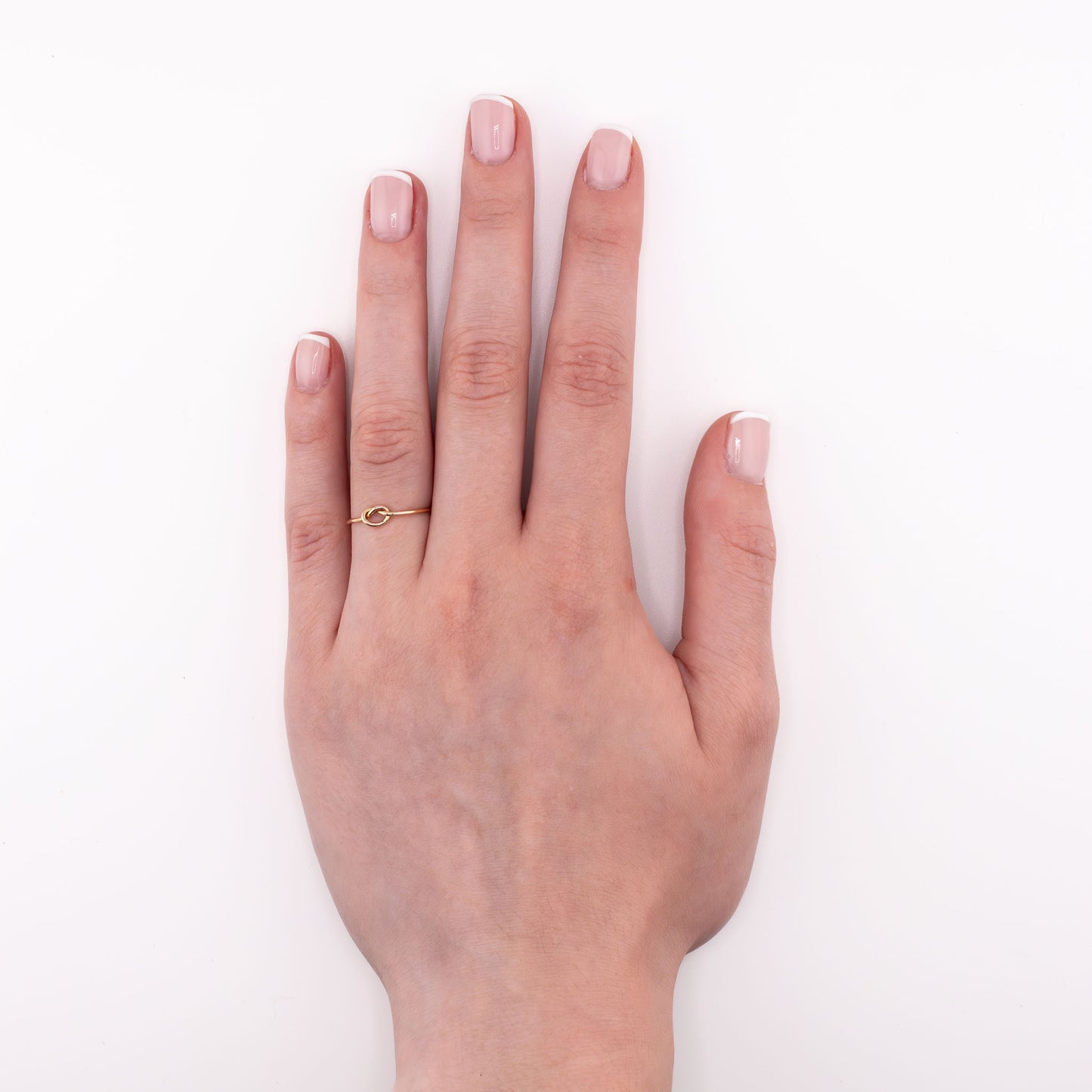 14k gold-filled Tiny Knot stacking ring on hand model, simple minimalist knot jewelry for everyday stacking