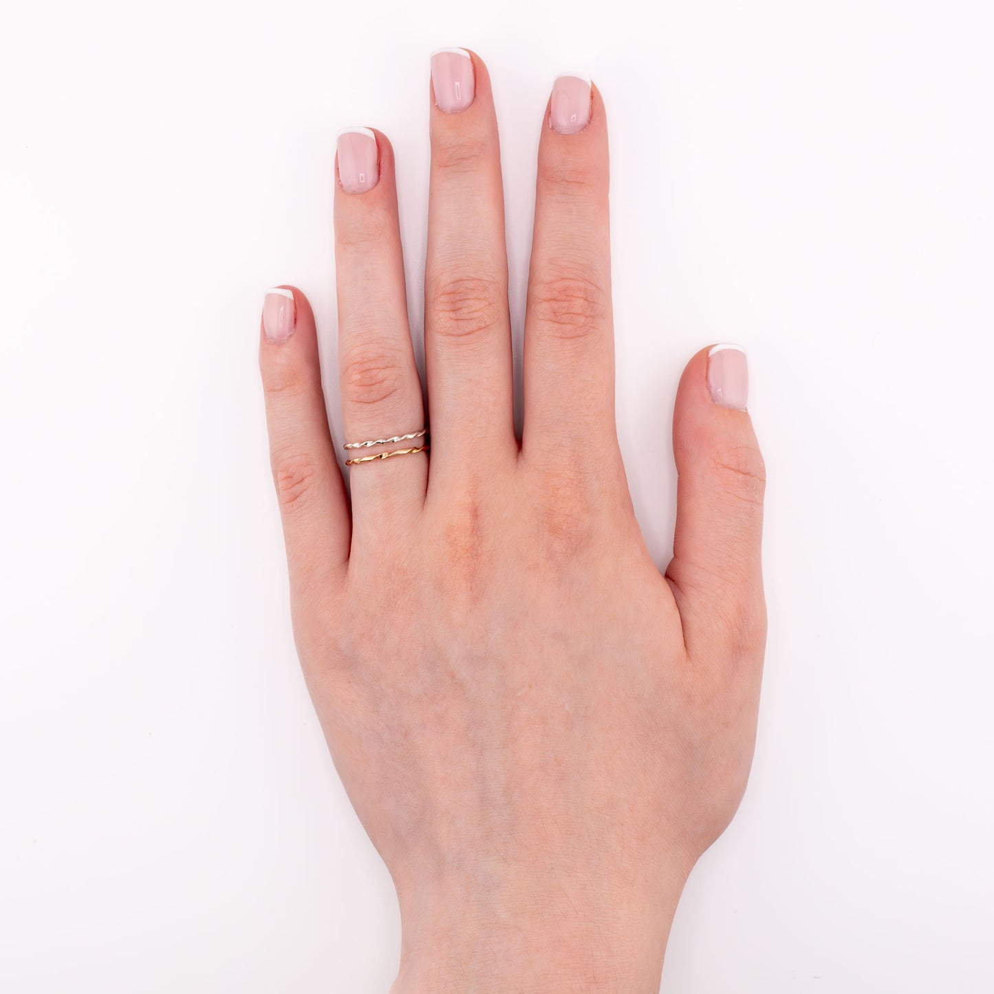 Tiny Twist stacking rings layered in sterling silver and 14k gold-filled, dainty twisted design for everyday wear