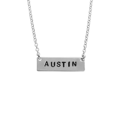 A sterling silver chain necklace with the word 'Austin' stamped on it, displayed against a white background.