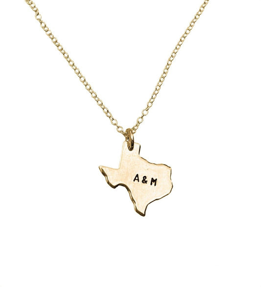 Gold necklace with a Texas-shaped pendant featuring 'A & M' on a white background