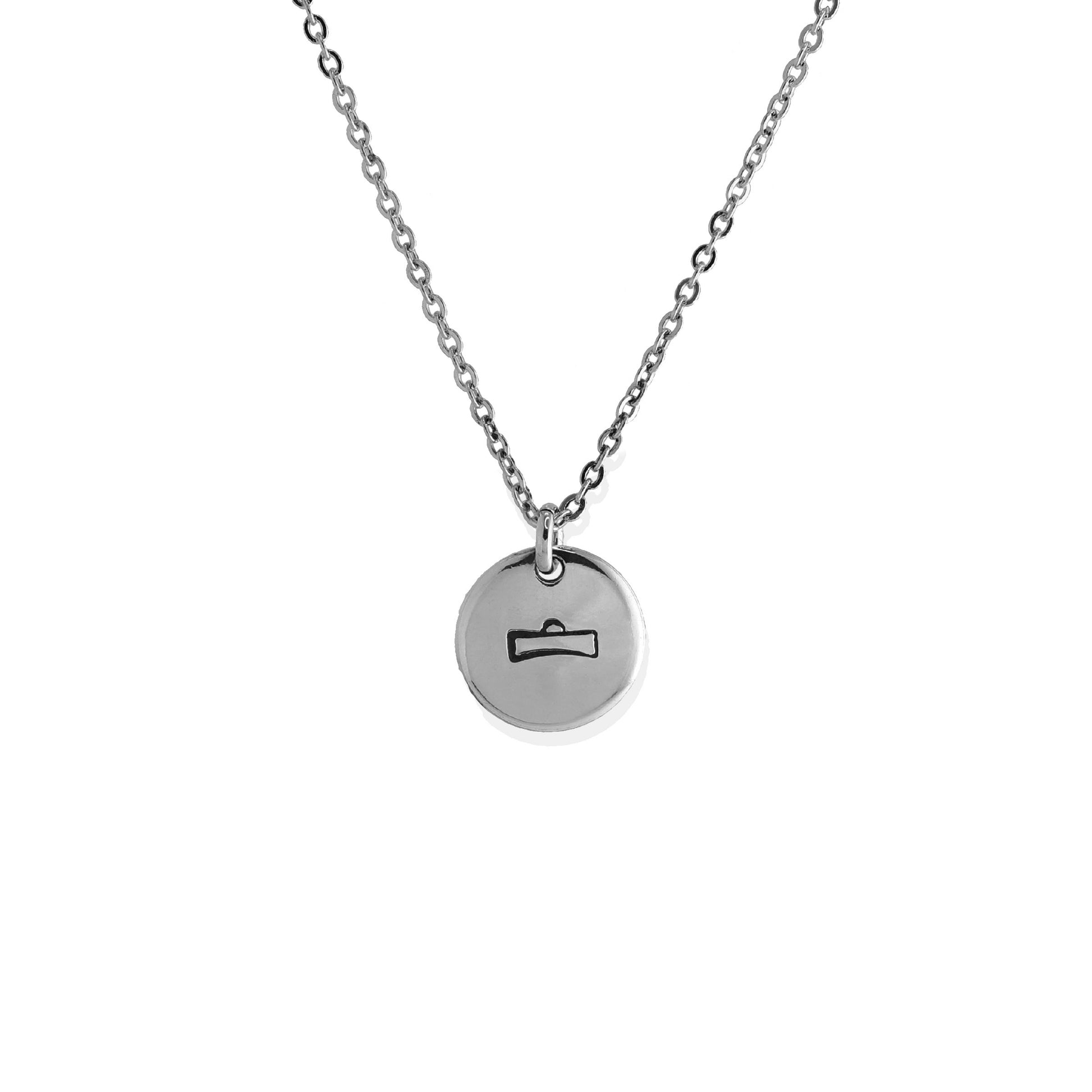 A silver necklace with a circular charm featuring the Libra symbol.