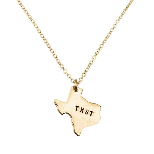 Gold necklace with a Texas-shaped pendant showing 'TXST' on a white background
