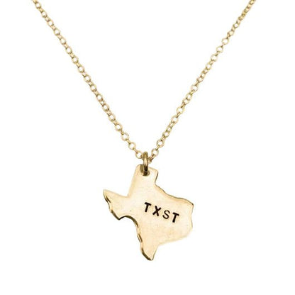 Gold necklace with a Texas-shaped pendant showing 'TXST' on a white background