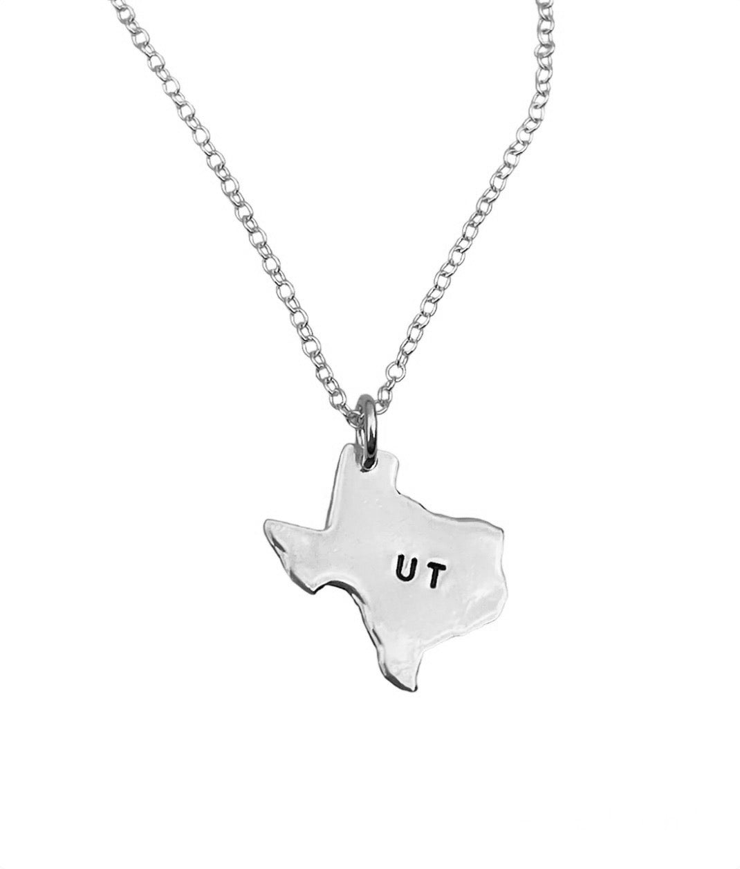 Silver necklace with a Texas-shaped pendant inscribed with 'UT' on a white background