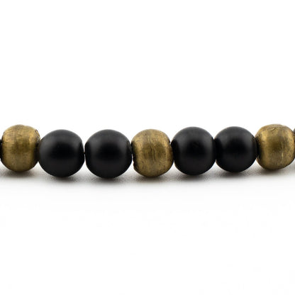 Close-up of polished black onyx beads with glossy finish, handmade yoga bracelet from Texas.
