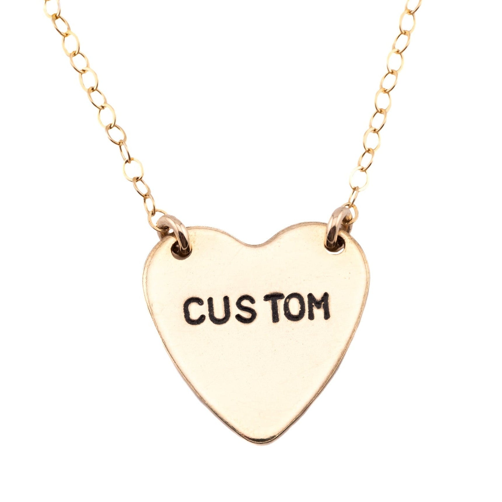 Gold heart-shaped necklace with 'CUSTOM' engraving on a white background