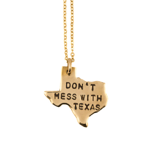 Gold necklace with a Texas-shaped pendant shows 'Don't mess with texas' on a white background