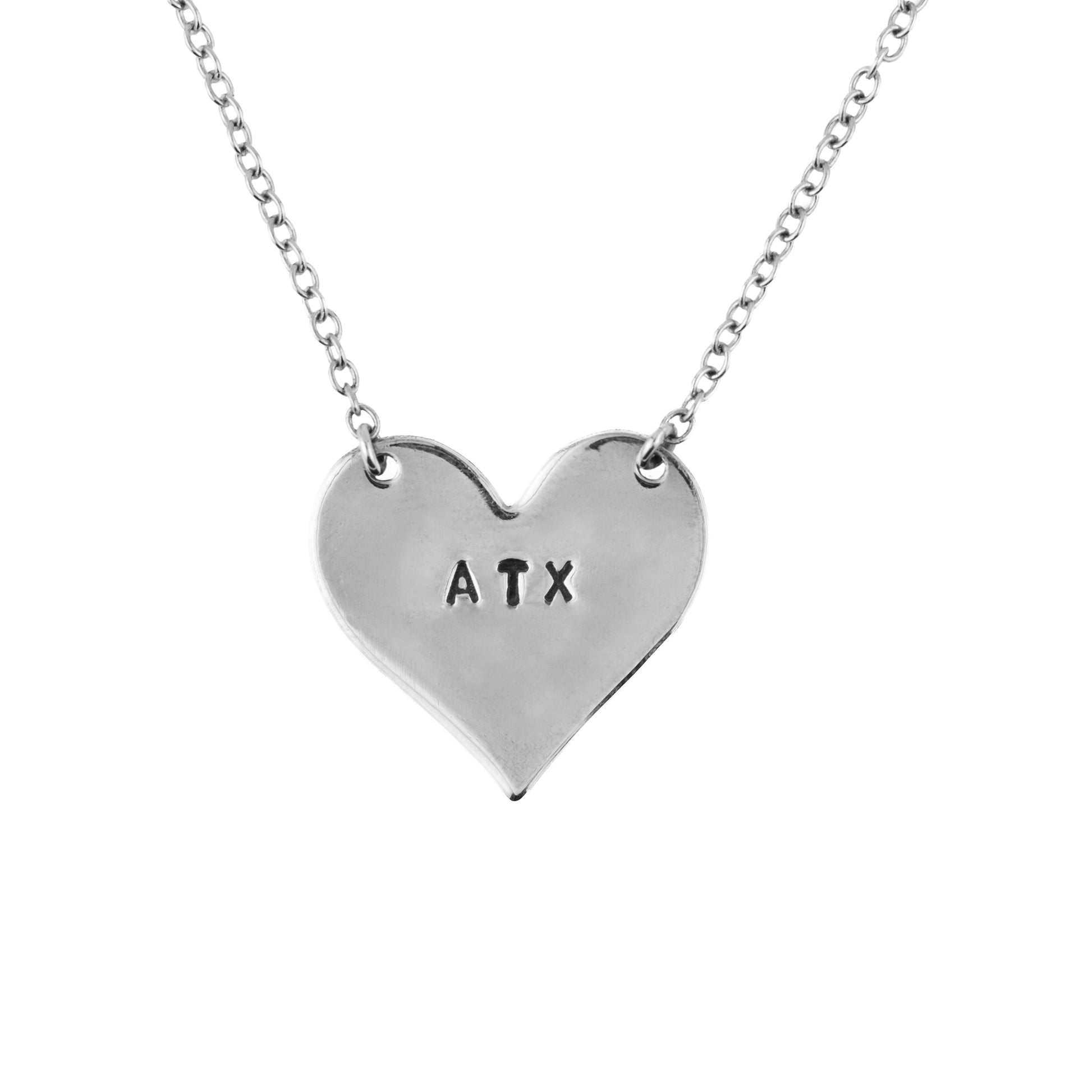 Silver heart-shaped necklace with 'ATX' engraving on a white background