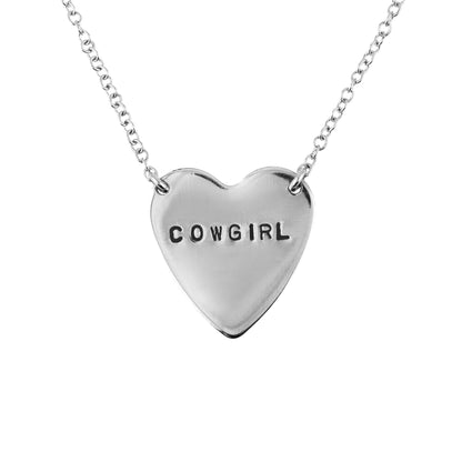 Silver heart-shaped necklace with 'COWGIRL' engraving on a white background