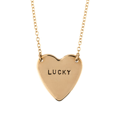 Gold heart-shaped necklace with 'LUCKY' engraving on a white background