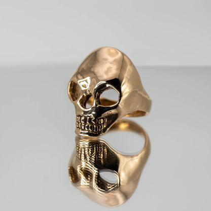 Bronze Skull Ring on mirror with reflection, handmade artisan jewelry crafted in Texas, USA
