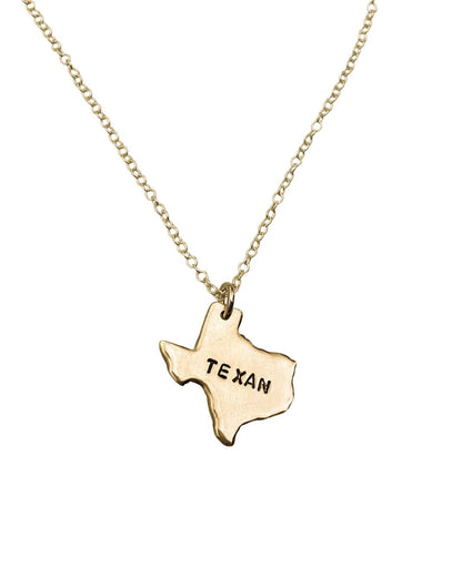 Gold necklace with a Texas-shaped pendant on a white background