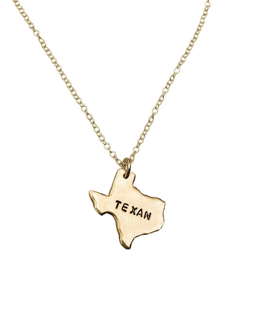 Gold necklace with a Texas-shaped pendant on a white background