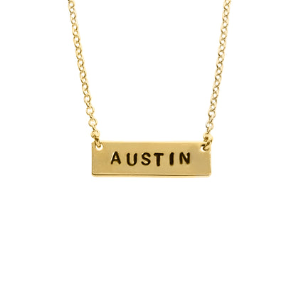A gold-filled chain necklace with the word 'Austin' stamped on it, displayed against a white background.